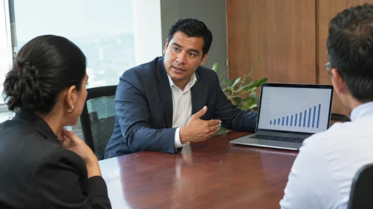 Salesman presenting to clients at a conference table - American English Pitch and Intonation for Sales