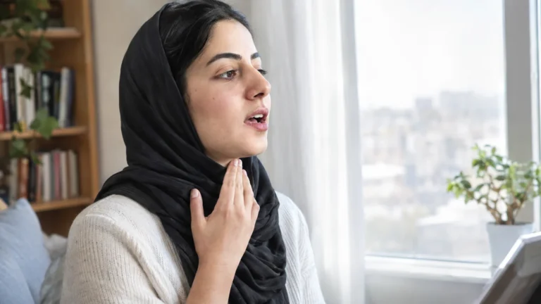Woman practicing words with her hand on her throat - Pronounce ed Endings by Feeling the Voicing: 3 Sounds to Practice