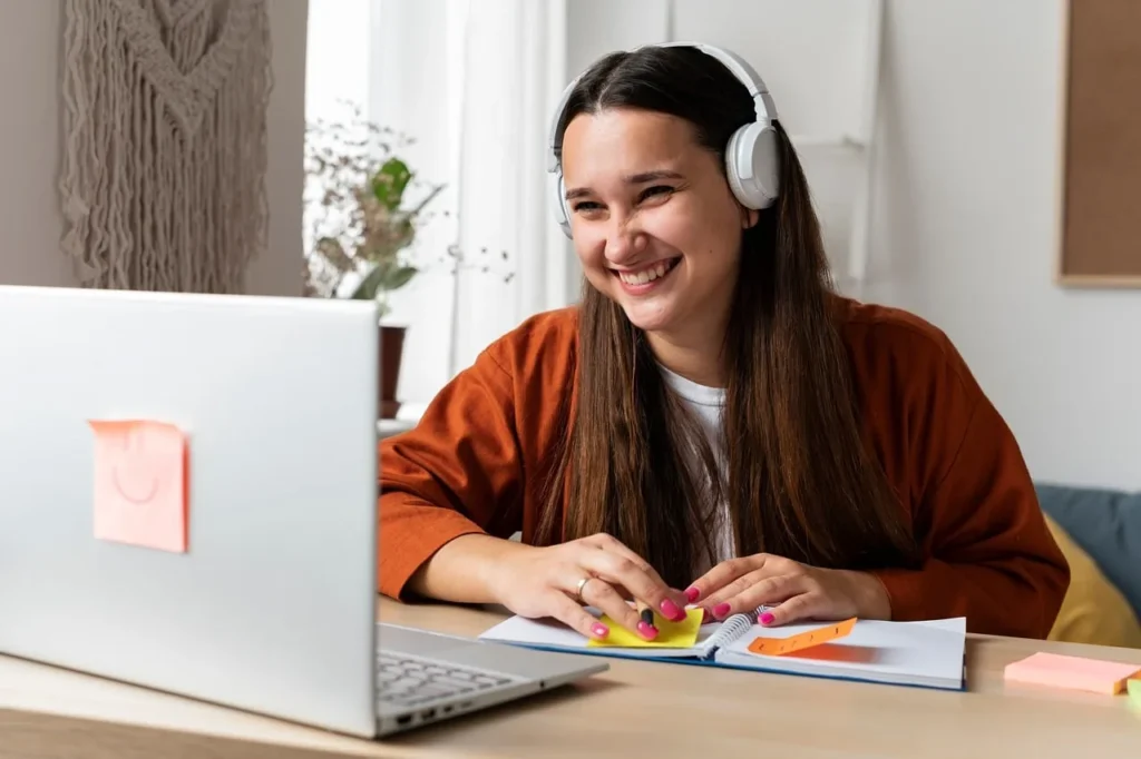 Woman, headphones, notebook - Top 4 AccurateEnglish.com Alternatives 2026